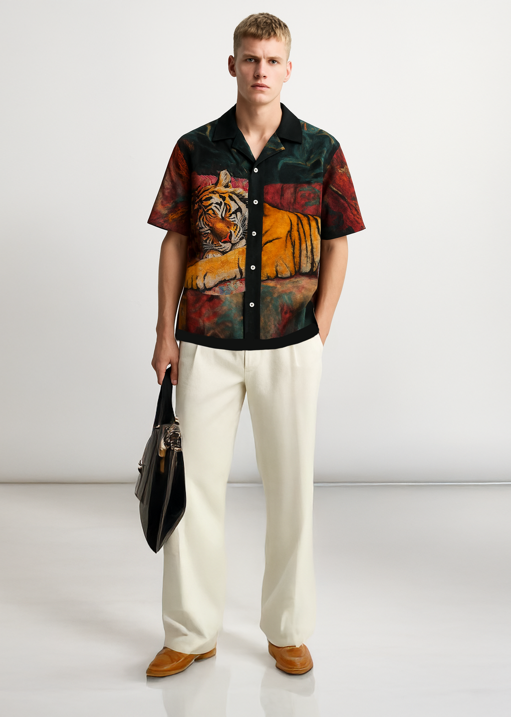 Man wearing a colorful shirt with a tiger design and white pants on a white background